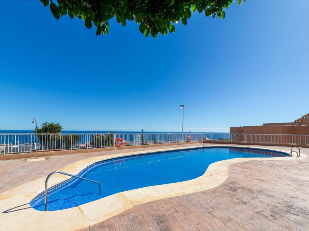 a swimming pool with the ocean in the background at Apartment Marina de la Torre by Interhome in Mojácar