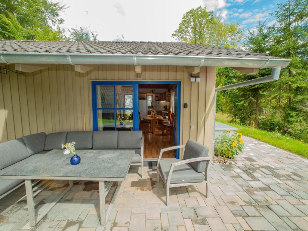 eine Terrasse mit einem Sofa, einem Tisch und Stühlen in der Unterkunft Holiday Home Ferienhaus Bude 87 by Interhome in Bad Arolsen