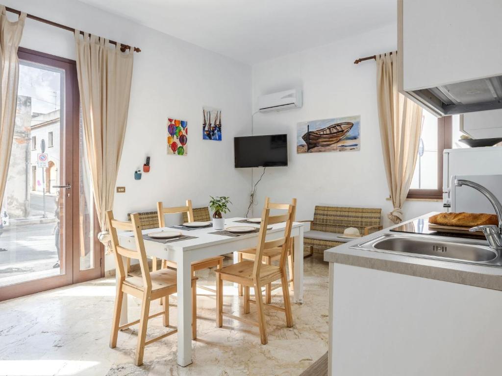 サン・ヴィート・ロ・カーポにあるApartment Savoia by Interhomeのテーブルと椅子のあるキッチンとダイニングルーム