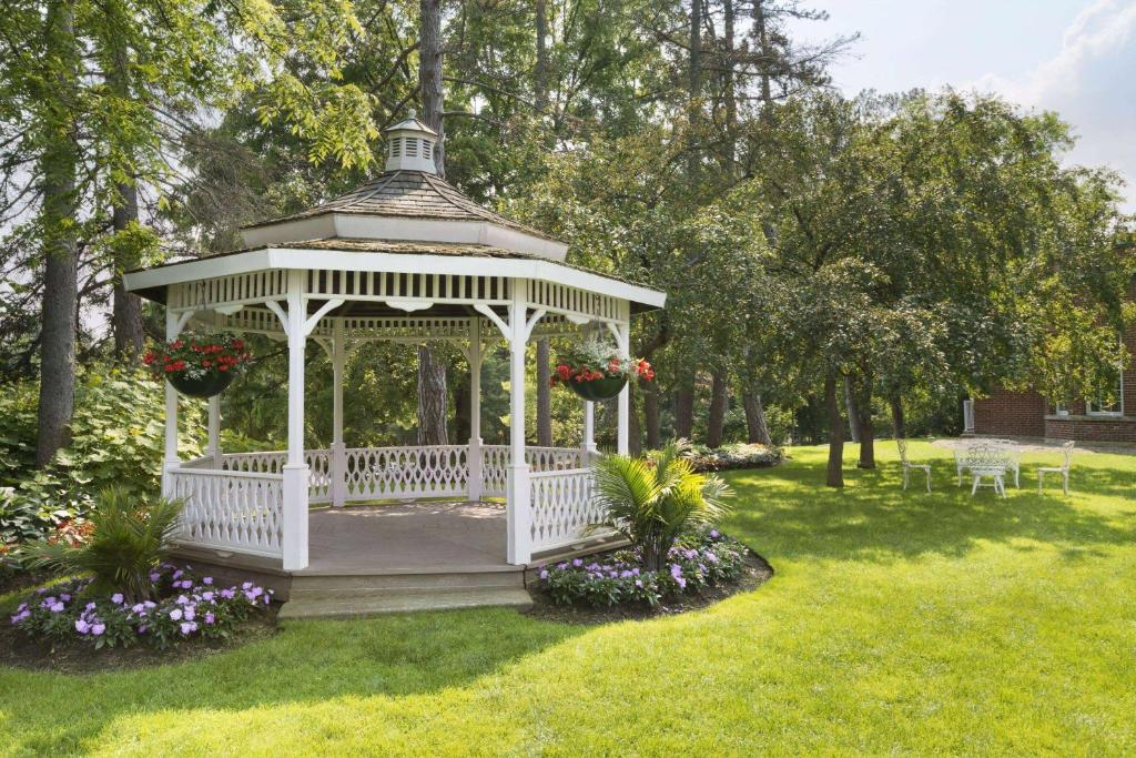 a white gazebo in a park with flowers at Ivey Spencer Leadership Centre, a Dolce by Wyndham in London