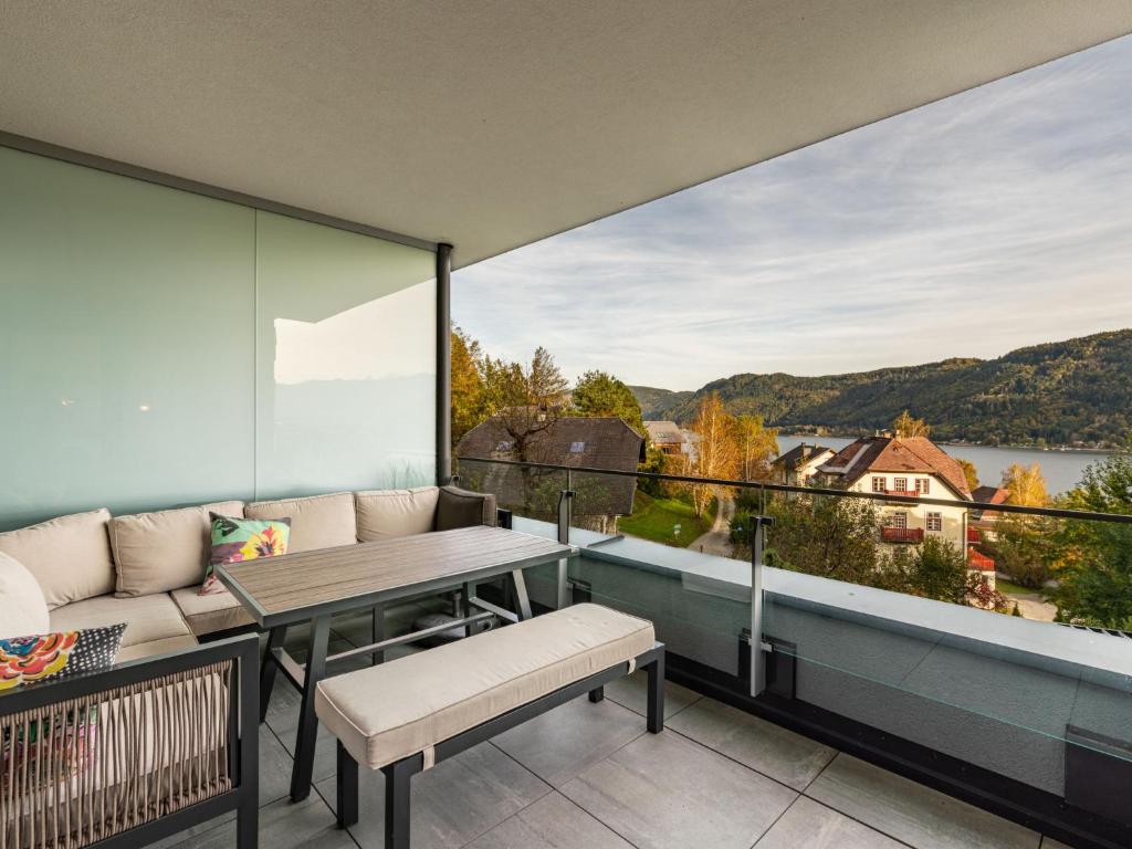 einen Balkon mit einem Tisch und einer Bank sowie Aussicht in der Unterkunft Apartment Seeblick alpe maritima Ski & See-Top 12 by Interhome in Annenheim