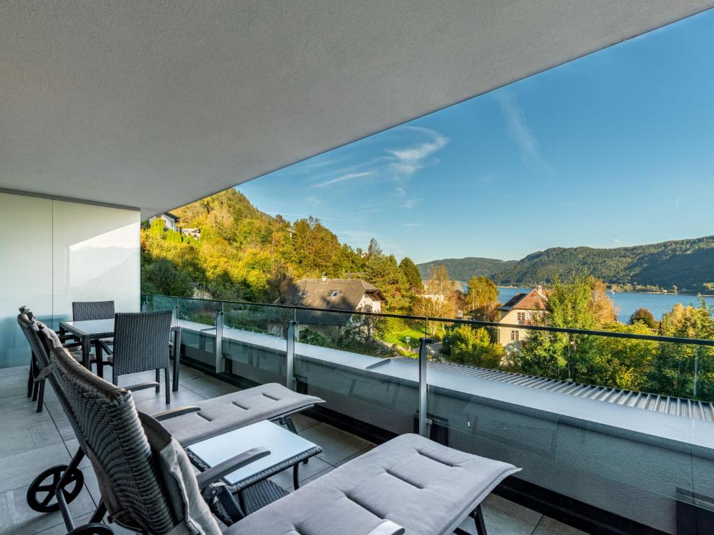 a balcony with chairs and a view of the water at Apartment Berg- und Seeblick alpe maritima -Top 10 by Interhome in Annenheim