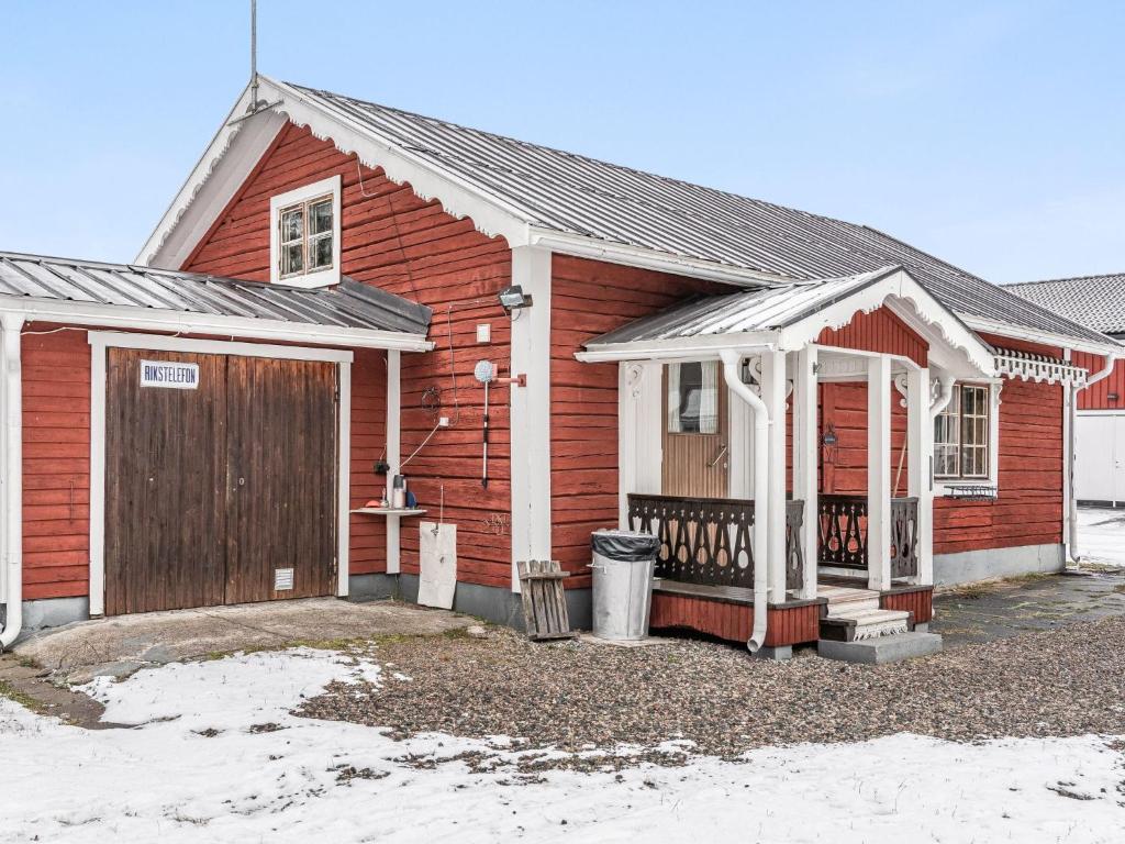 Casa roja con puerta de madera y porche en Chalet Norrskensstugan - NBO010 by Interhome, en Vidsel