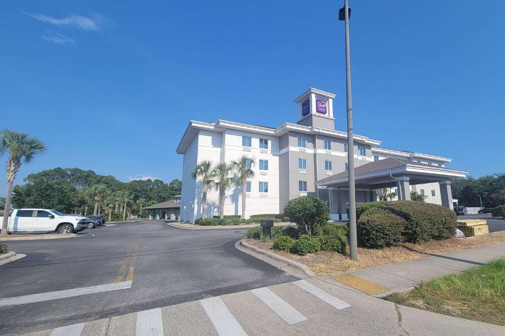 um grande edifício branco com uma torre de relógio numa rua em Sleep Inn & Suites Panama City Beach em Panama City Beach