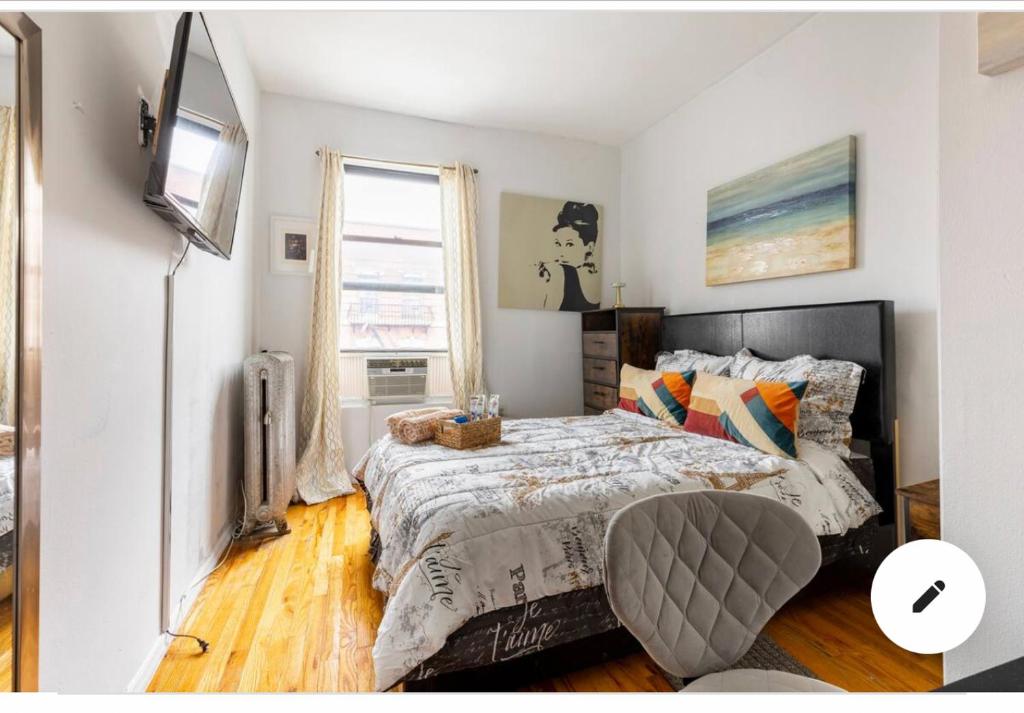 ein Schlafzimmer mit einem Bett und einem TV in der Unterkunft Deluxe Manhattan room in New York