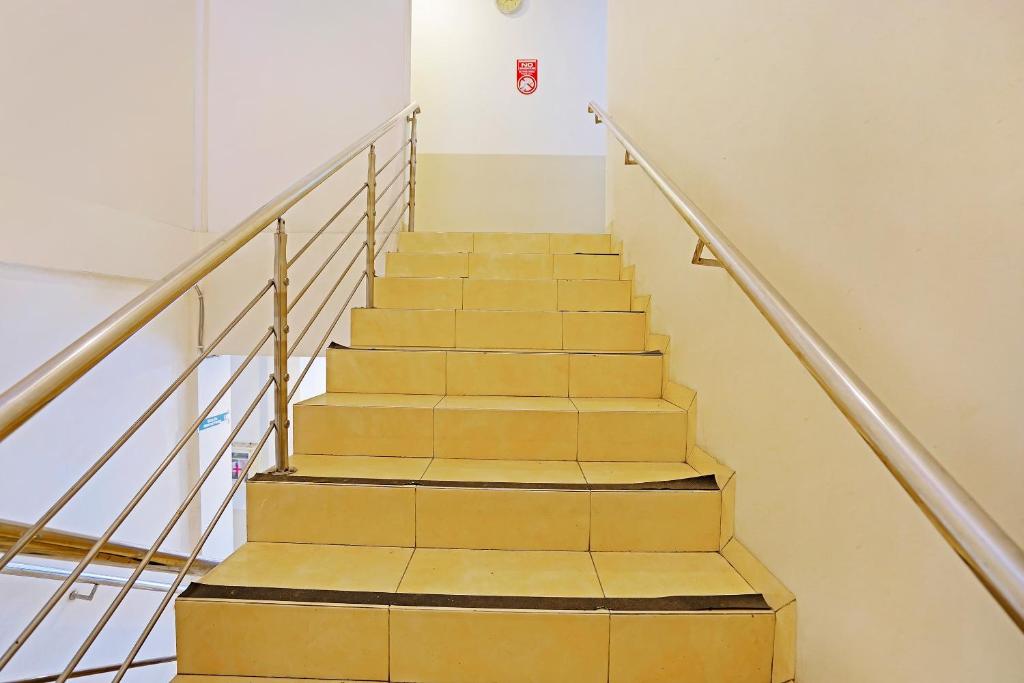 una escalera en un edificio con escalones de madera en OYO Flagship 91290 Pondok Inap Shofwa 2 en Dares