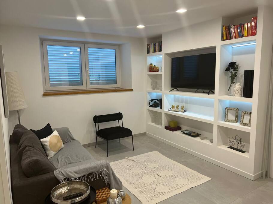 ein Wohnzimmer mit einem Sofa und einem Flachbild-TV in der Unterkunft Appartamento Casa Roby in Montecatini Terme