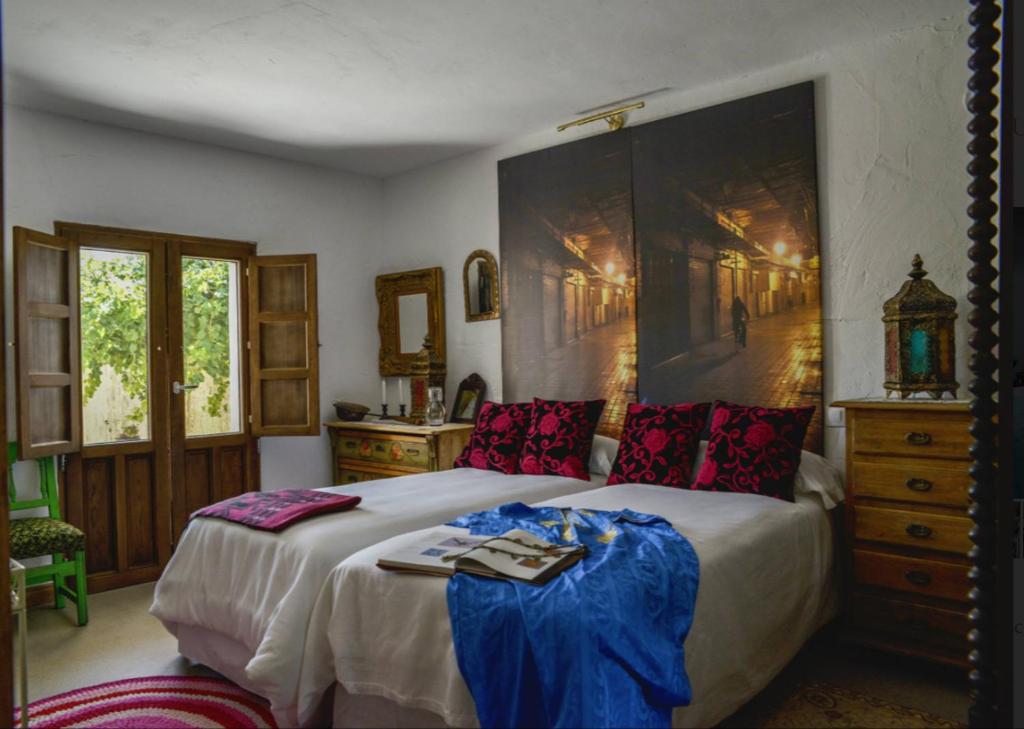 - une chambre avec un grand lit et une grande peinture murale dans l'établissement Los Diezmos, à Torremocha de Jarama