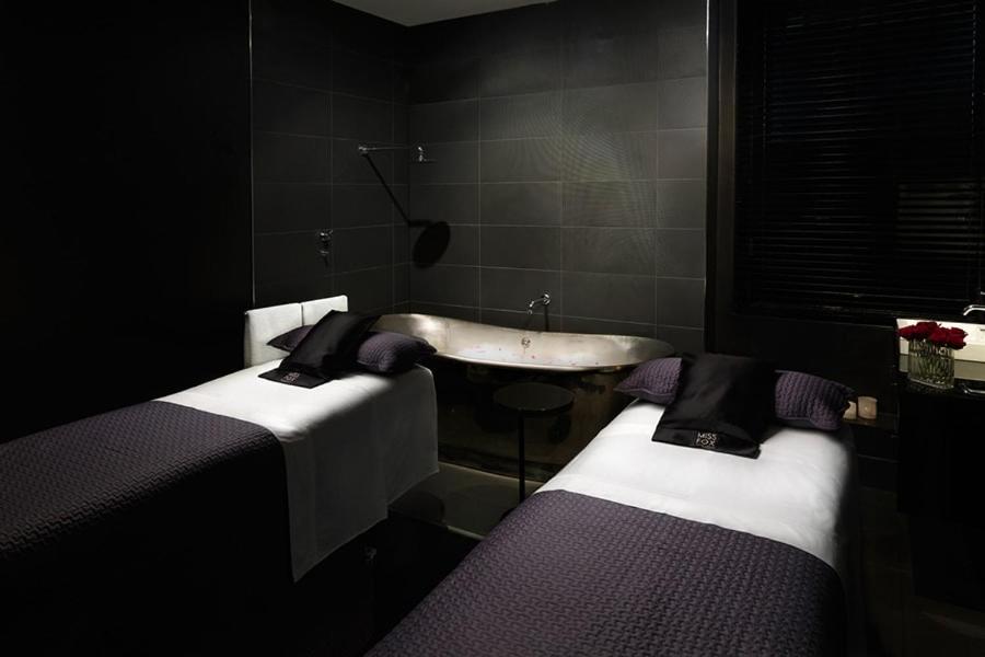 康提的住宿－KANDY WELLNESS & THAI SPA，一间带水槽的浴室和两张床。