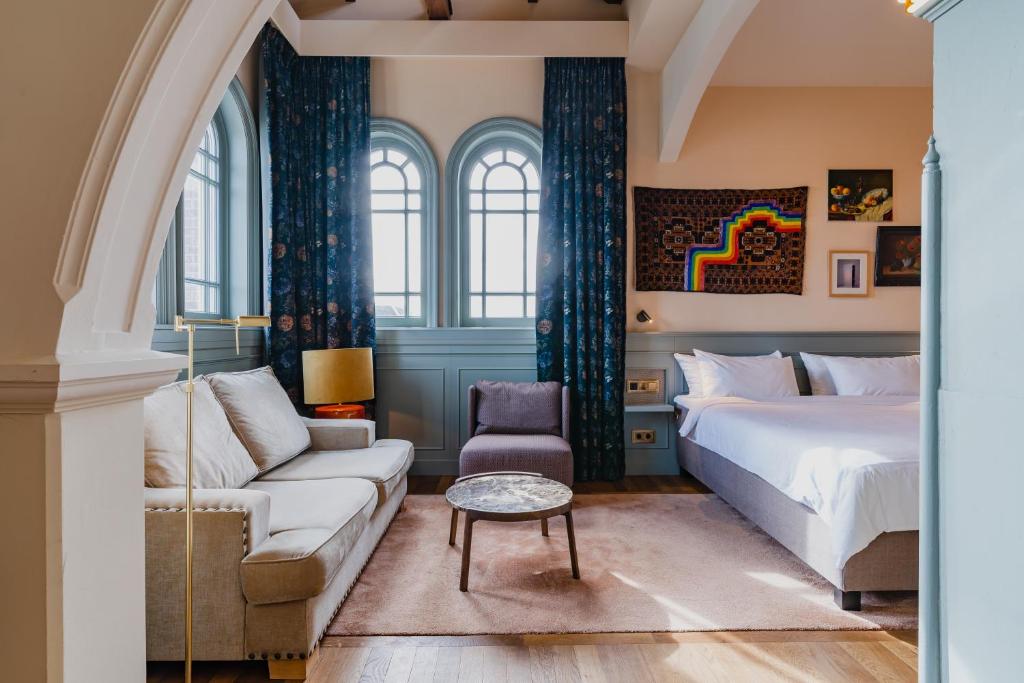 a bedroom with a bed and a couch at Hotel Mercier in Amsterdam
