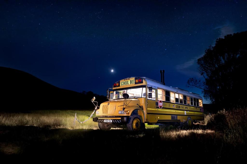 Ein Schulbus parkt nachts auf einem Feld in der Unterkunft Skoolie Stays - Luxury American school bus conversion in Storrington