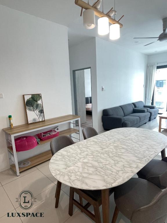 - un salon avec une table et des chaises blanches dans l'établissement Kuching Near Batu Kawa Cozy Apartment P Residence, à Kuching