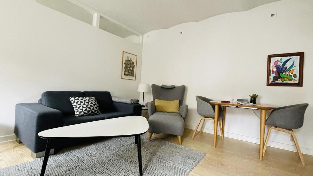 uma sala de estar com um sofá azul e cadeiras em ApartmentInCopenhagen Apartment 1207 em Copenhague