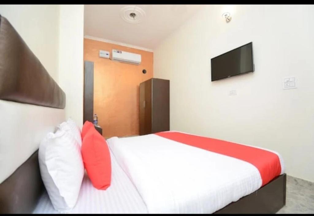 a bedroom with a bed with red pillows and a television at Hotel spring in Zirakpur