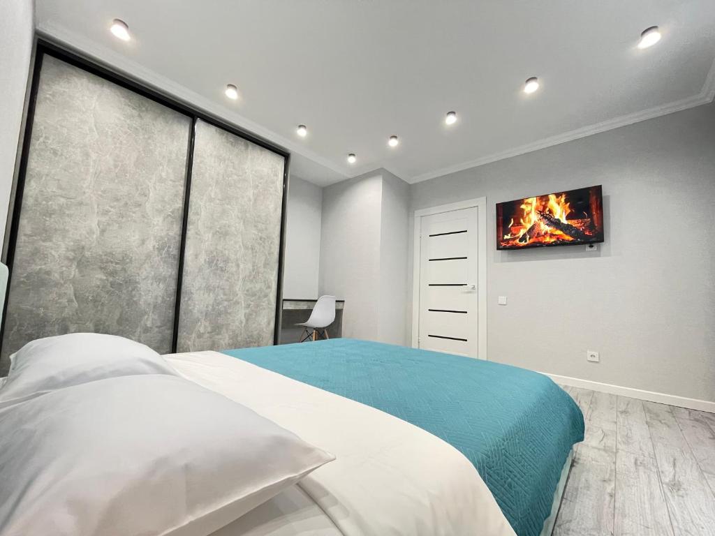 um quarto com uma cama e uma televisão na parede em Апартаменты Freedom Greenline Сыганак Хан Шатыр em Taldykolʼ