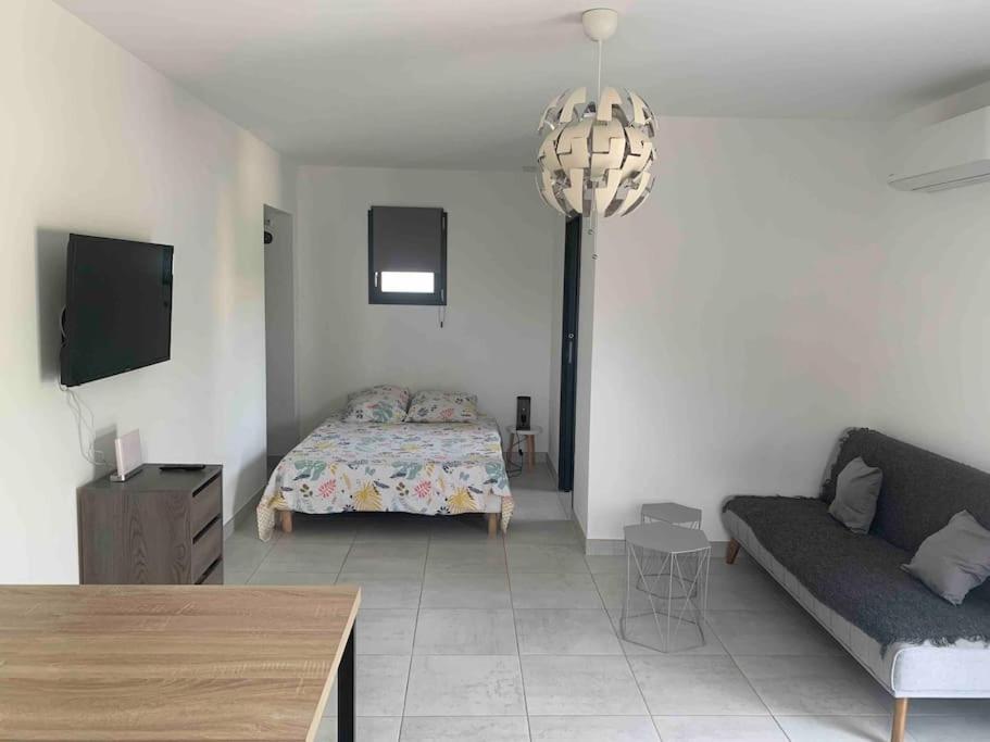 - un salon avec un lit et un canapé dans l'établissement Studio Rousson, à Rousson