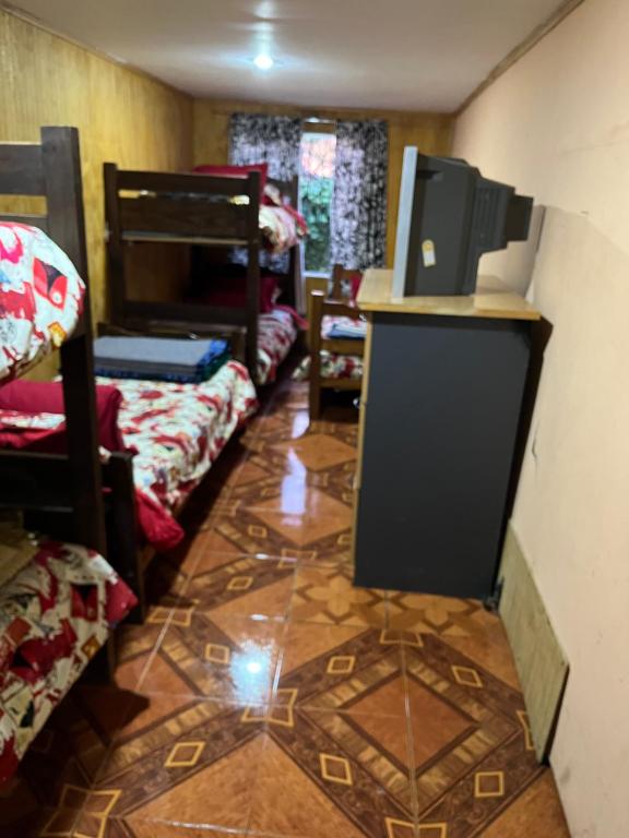 Habitación con suelo de baldosa y habitación con literas. en Casa en el tabo, en San Antonio