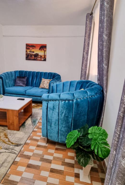 Sofá azul en la sala de estar con mesa en Spacious 1 bedroom with Parking Nakuru, en Nakuru