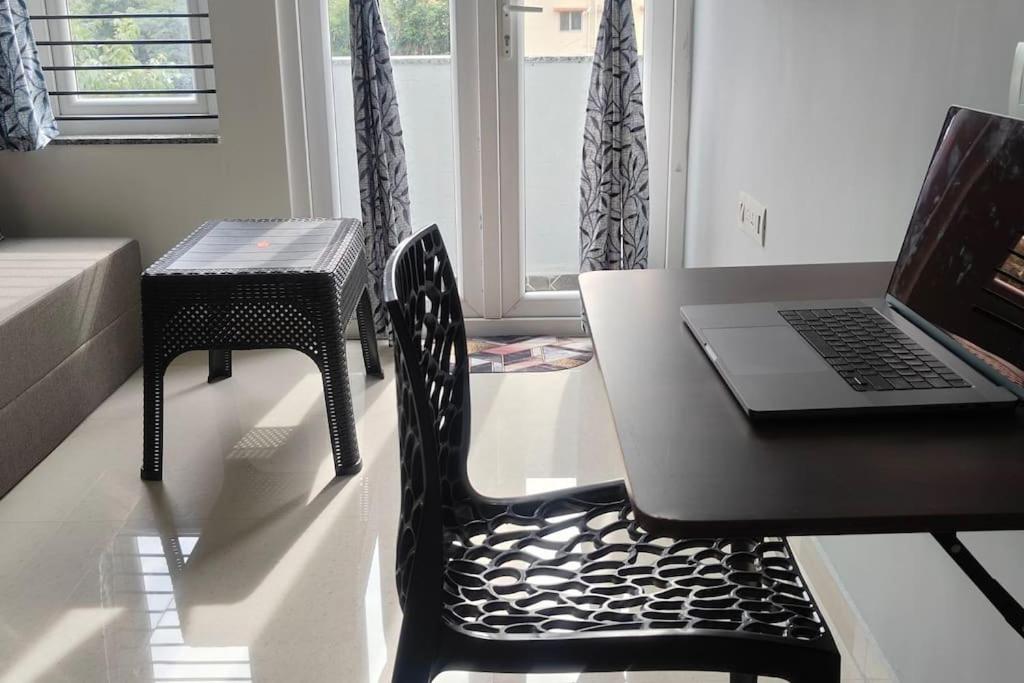 un escritorio con un ordenador portátil en una mesa con una silla en Compact yet beautiful 1bhk 001, en Bangalore