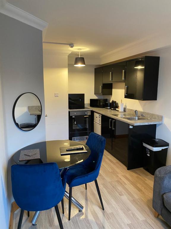 a kitchen with a table and two blue chairs at 1 bedroom apartment in Norwich city centre in Norwich