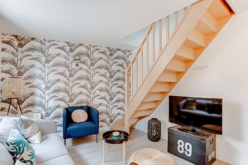 a living room with a couch and a staircase at Petite maison de charme à 10 minutes de Disney ! in Montévrain