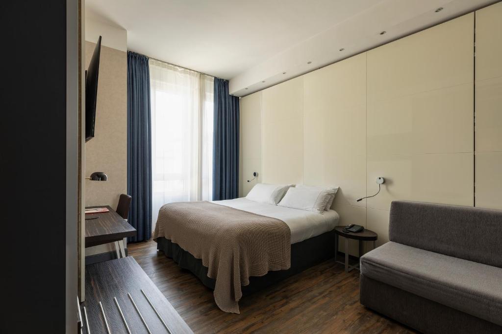ミラノにあるC ホテルズ アトランティックのベッドとソファ付きのホテルルーム