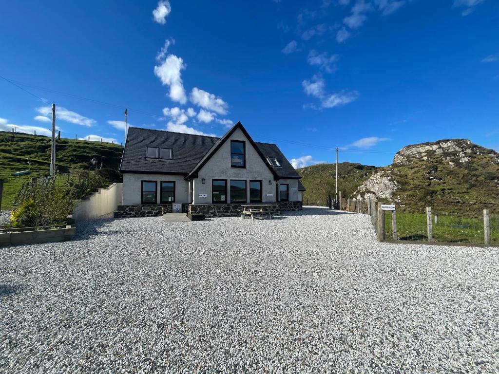 a house on a gravel driveway at The Bridge B&B in Kilmaluag