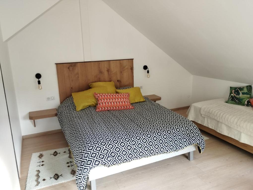 1 dormitorio con 1 cama con almohadas amarillas y rojas en l'écrin des biches en Sainte-Marie-aux-Mines