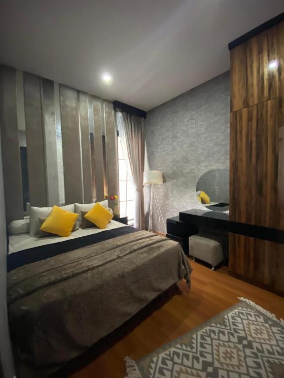 - une chambre avec un grand lit et des oreillers jaunes dans l'établissement Emerald Guesh House Type Paris Purwokerto, à Purwokerto