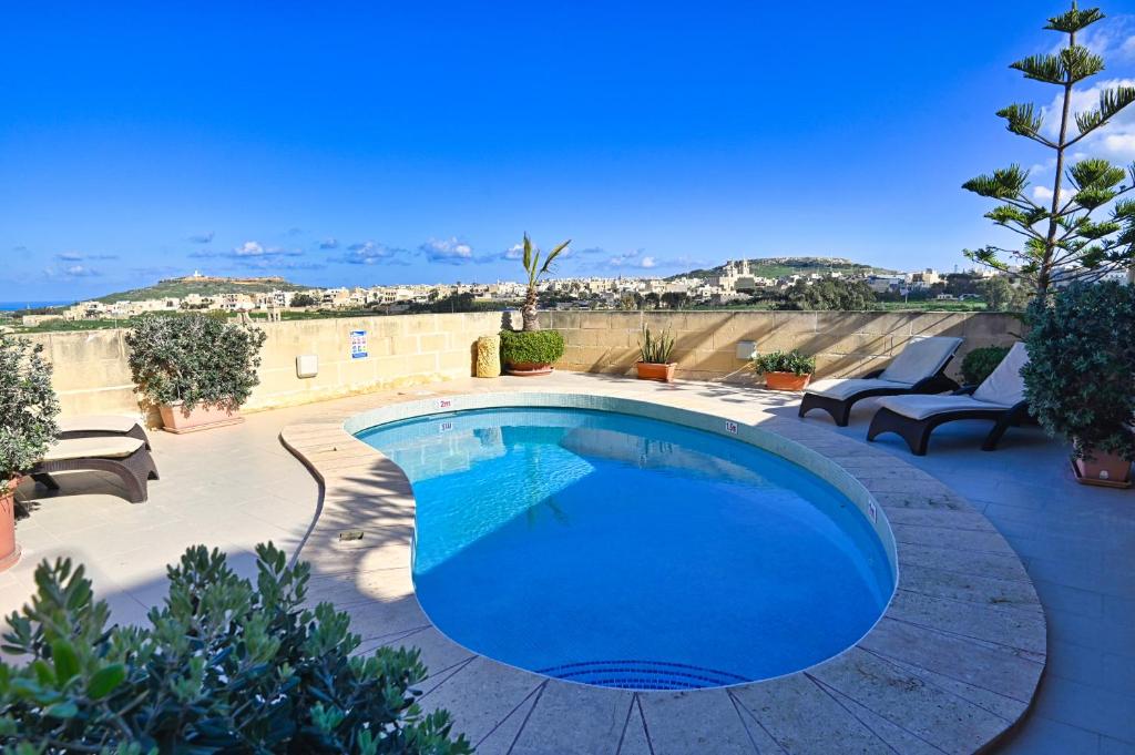 a large blue swimming pool on a patio at Mill House in Għarb