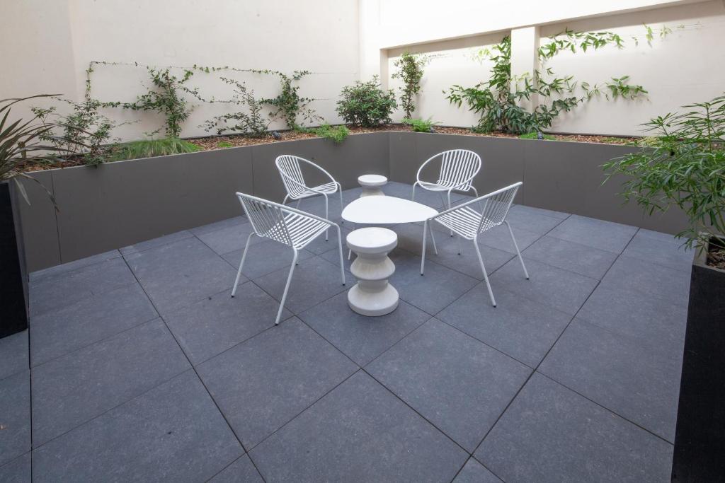 a white table and chairs on a patio at FINESTATE Coliving Champs-Elysées in Paris