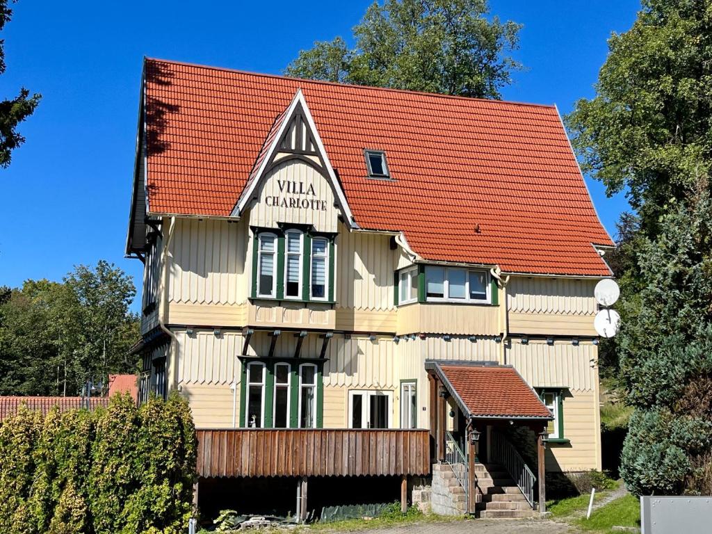 un grand bâtiment en bois avec un toit rouge dans l'établissement JS Feriendomizile: FeWo Charlotte, à Schierke