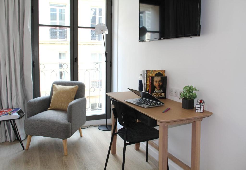 a desk with a laptop and a chair in a room at FINESTATE Coliving Champs-Elysées in Paris