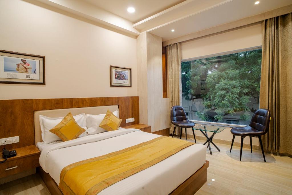 a hotel room with a bed and a large window at The Triana in Varanasi