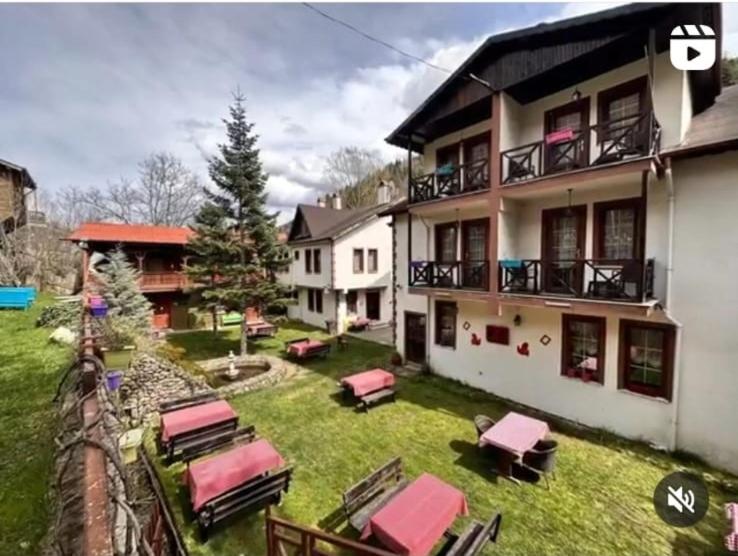 una casa con un patio con tumbonas y un patio en ABANT DORT MEVSİM KONAĞI HOSTEL, en Dereceören