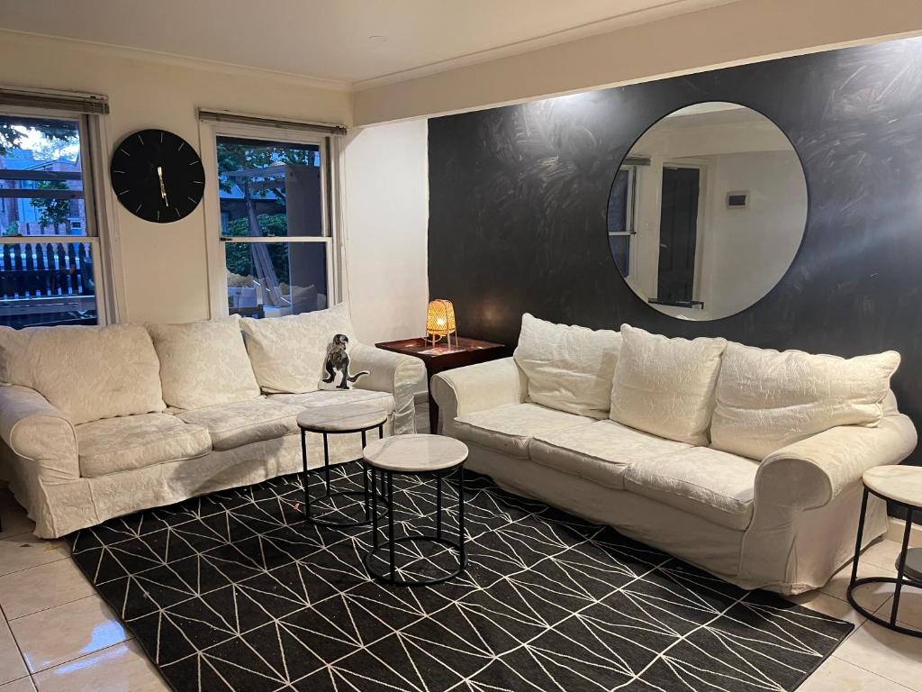 墨爾本的住宿－Luxury Fitzroy House，客厅配有两张沙发和一面镜子