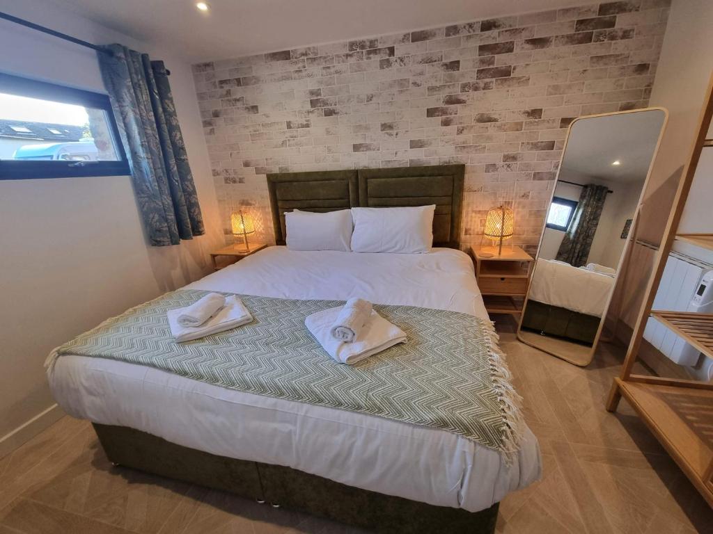 Rudgleigh Lodge by Cliftonvalley Apartments في بريستول: غرفة نوم عليها سرير وفوط