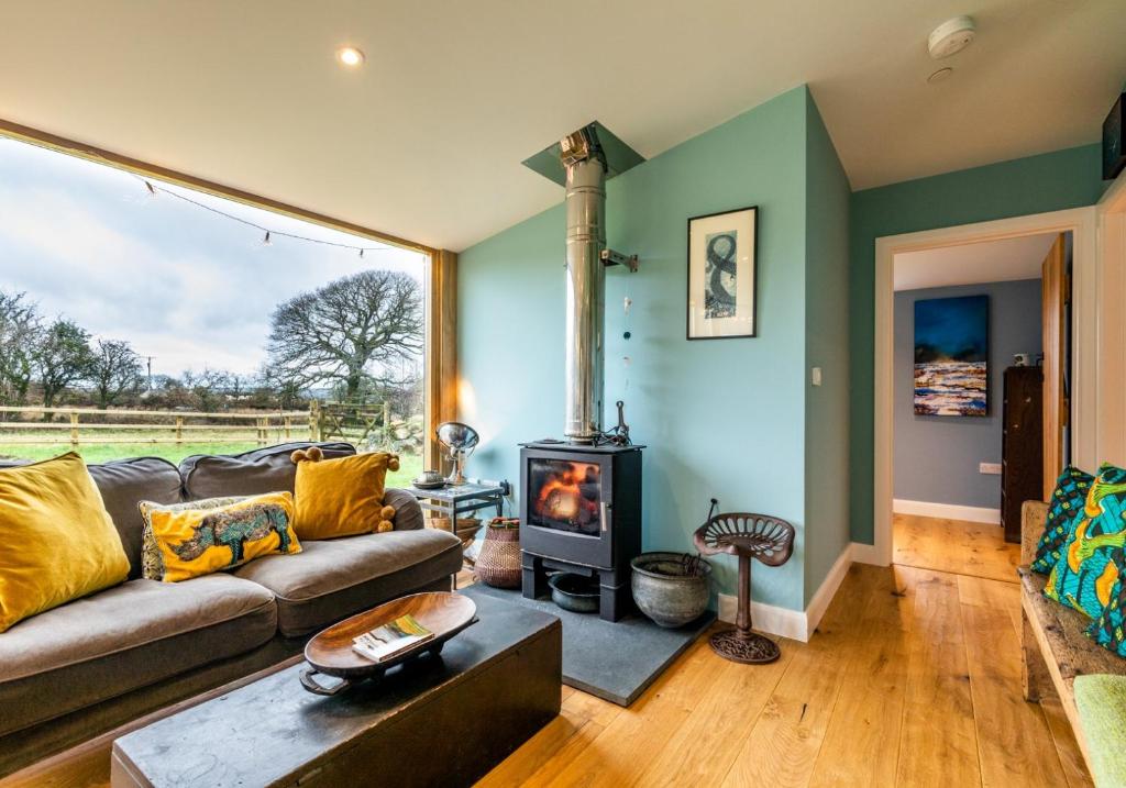 a living room with a couch and a wood stove at Penrhiw - a country cottage with mountain views in Newport Pembrokeshire