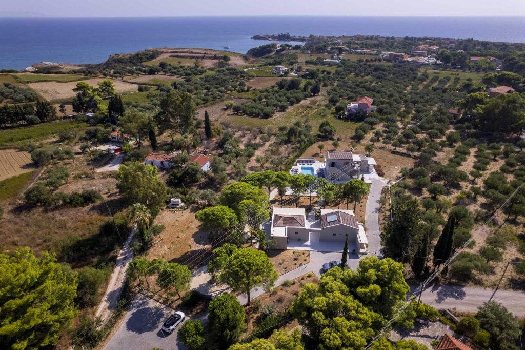an aerial view of a house with the ocean in the background at Alekos Beach Houses-Akrotiri Suites in Kounopetra