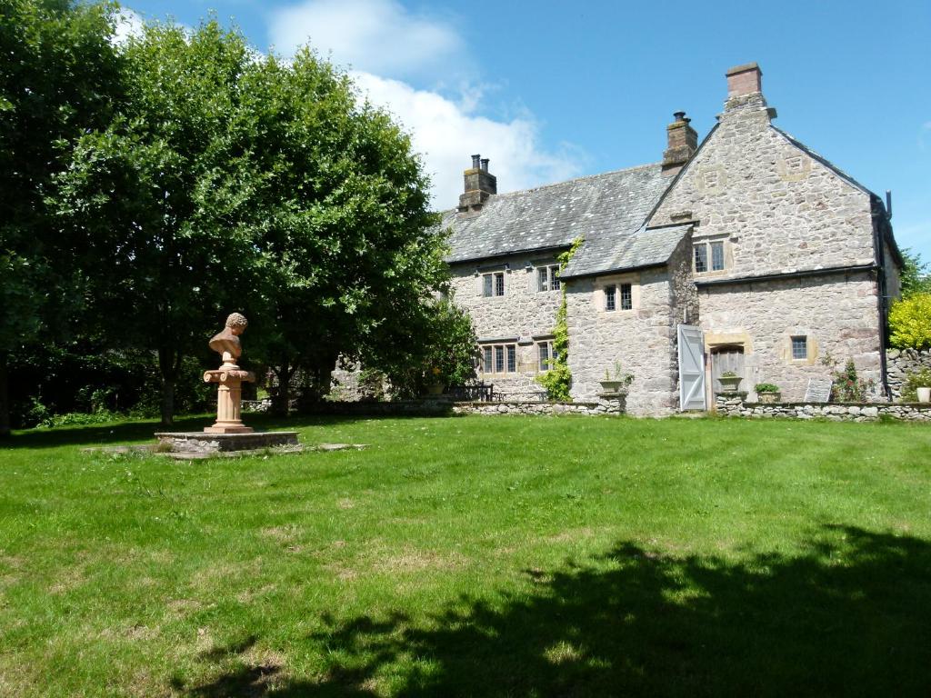 an old stone house with a statue in the yard at The Hall in Penrith