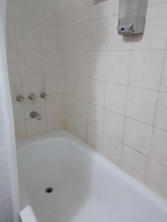 y baño con ducha y bañera blanca. en Alquiler de casa en Rio Grande Tierra del Fuego en Río Grande