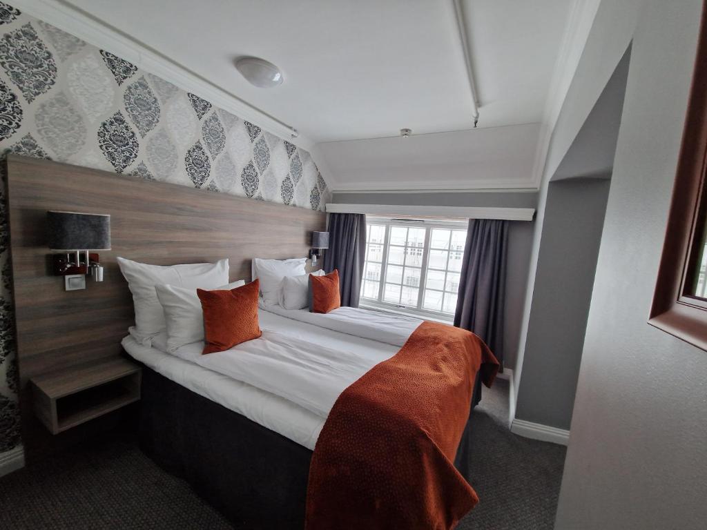 Postel nebo postele na pokoji v ubytování Dr. Holms Hotel