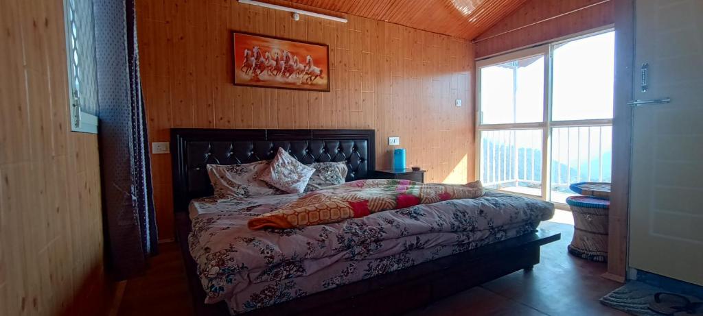 ein Schlafzimmer mit einem Bett in einem Zimmer mit einem Fenster in der Unterkunft TREE HOUSE BY THE CITY ESCAPE in Shimla