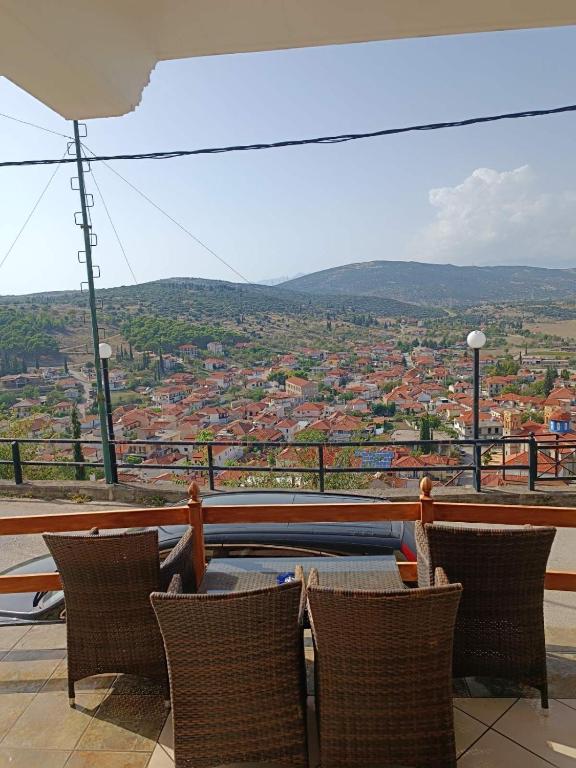 a balcony with chairs and a view of a city at Zorbas House in Dhesfína