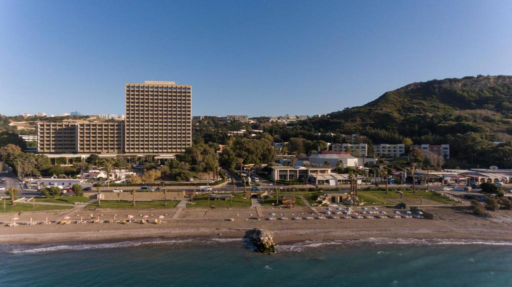 een uitzicht op een strand met een resort en gebouwen bij Rodos Palace Hotel in Ixia