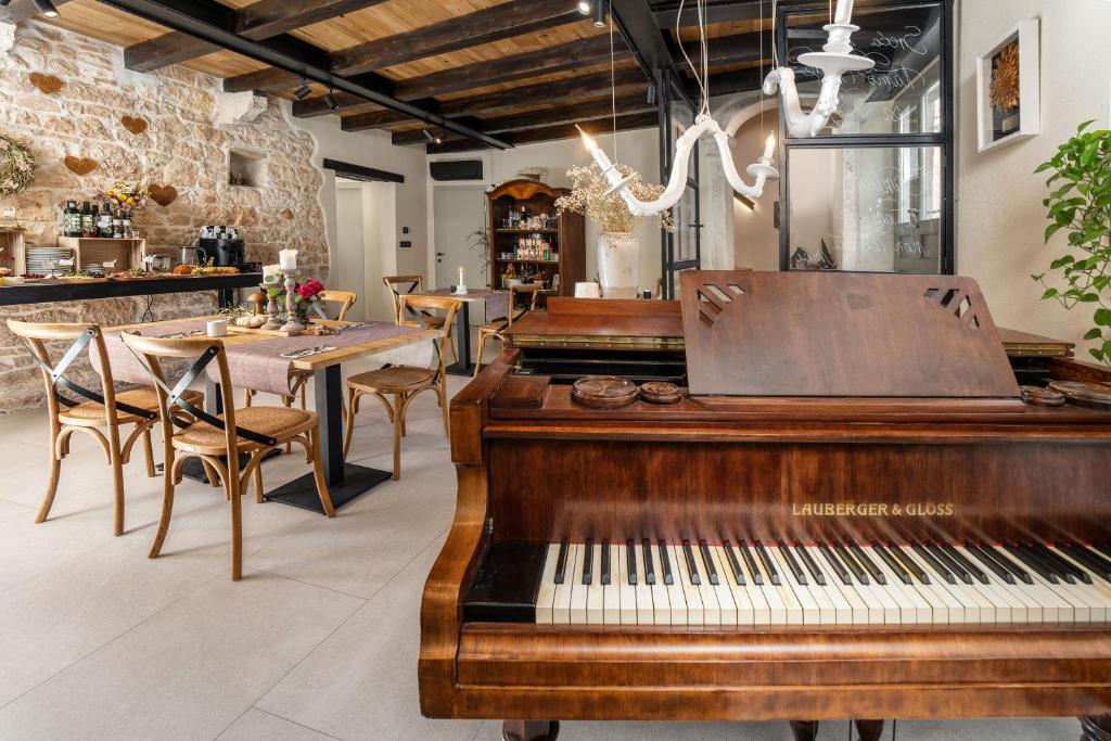 a piano in a restaurant with a table and chairs at Della Croce Bed&Breakfast in Svetvinčenat