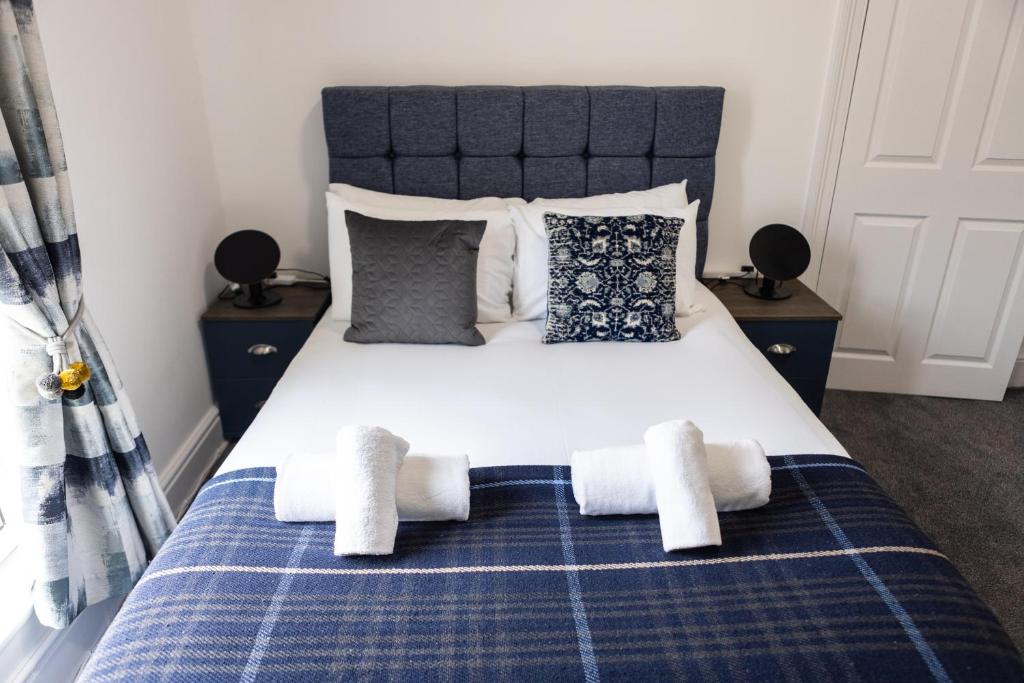 um quarto com uma cama azul e branca com toalhas em Fred's Place em Plymouth
