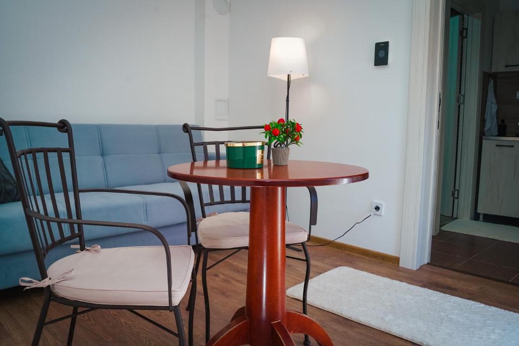 een tafel met twee stoelen en een lamp in de woonkamer bij BM Apartman in Gornji Milanovac