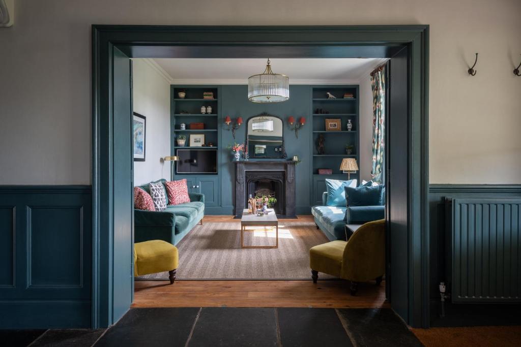 uma sala de estar com um sofá e uma lareira em Hummingbird House em Holbeton