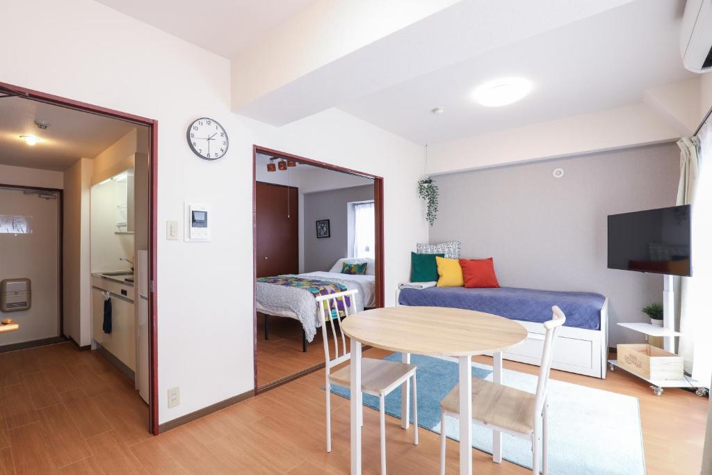 a living room with a table and a couch at Grande es TENJIN in Fukuoka